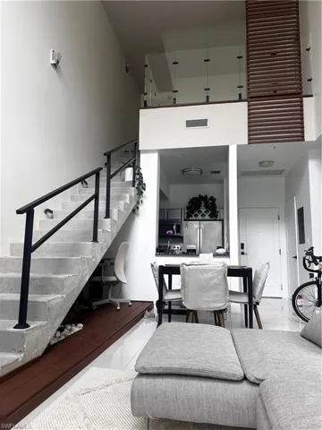 Stairway with a high ceiling and light tile floors