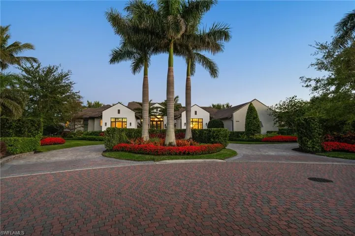 View of front of property featuring stucco siding and curved driveway