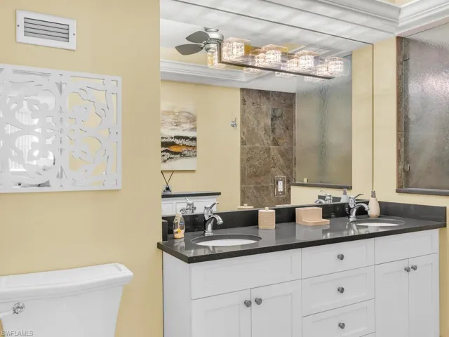 Bathroom featuring ceiling fan, vanity, and toilet
