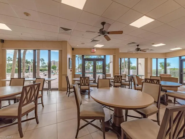 Dining area featuring light tile patterned flooring, ceiling fan, a paneled ceiling, and french doors