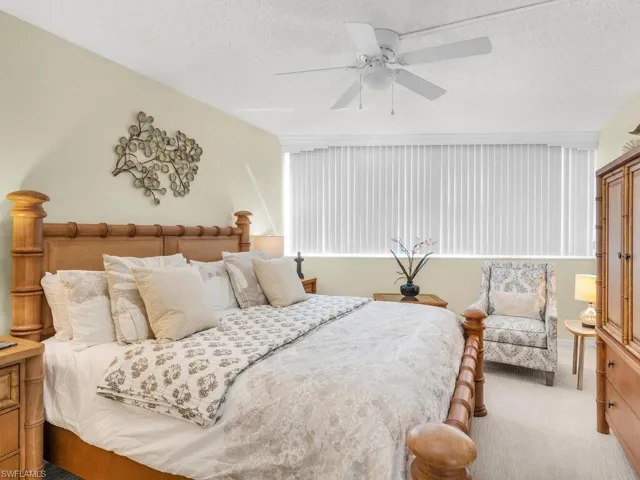 Bedroom featuring a textured ceiling, light carpet, and ceiling fan