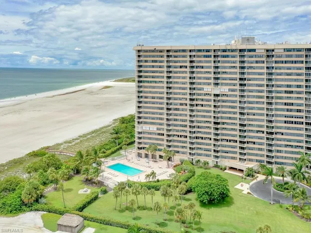 View of property featuring a view of the beach, a water view, and a community pool