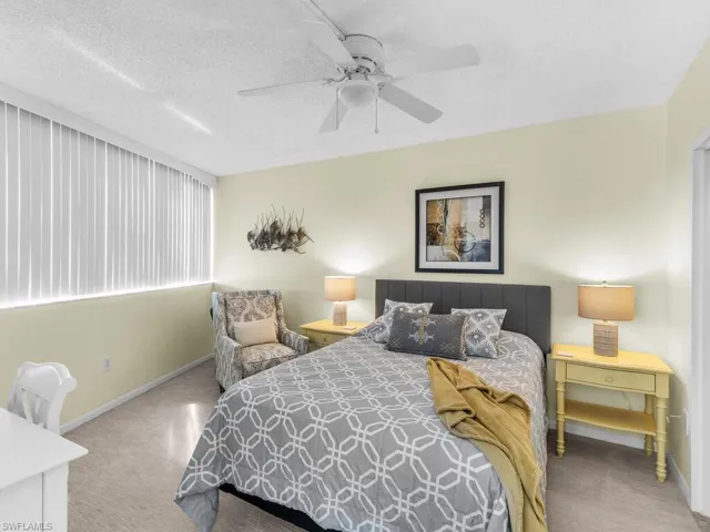 Carpeted bedroom featuring a textured ceiling and ceiling fan