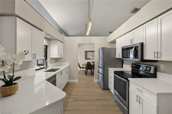 Kitchen featuring a sink, white cabinetry, visible vents, and appliances with stainless steel finishes