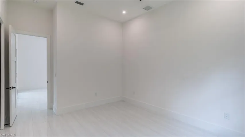 Bright room featuring light-toned flooring, white walls, and recessed lighting