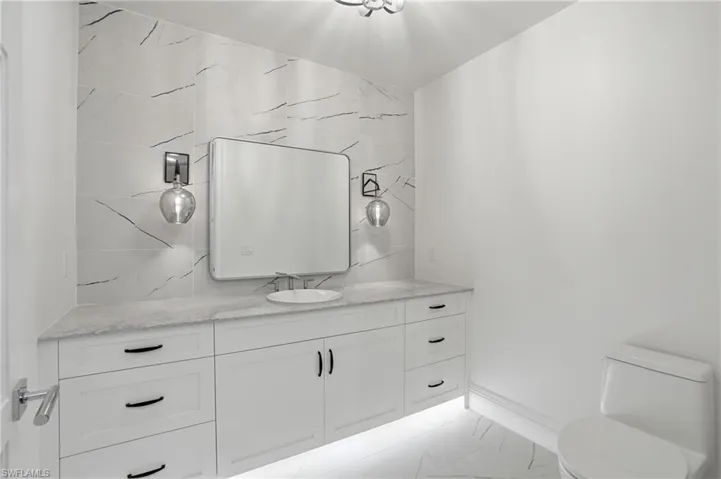 Bathroom with vanity and light marble finish flooring