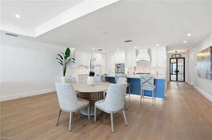 Dining room with light wood-style flooring and recessed lighting