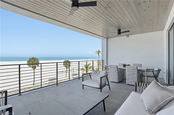 Balcony featuring a ceiling fan, a water view, and outdoor furniture