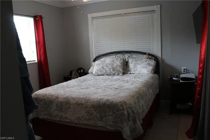 Bedroom featuring light tile patterned flooring and ornamental molding
