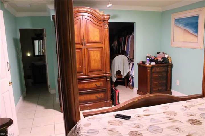 Bedroom featuring crown molding and light tile patterned floors