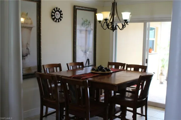 Dining area featuring decorative columns, a chandelier, and ornamental molding