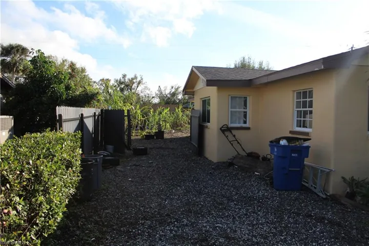 View of side of property with stucco siding and a shingled roof