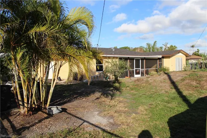 Rear view of house with a sunroom and a shingled roof