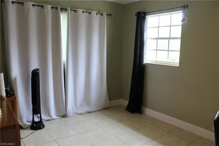 Empty room featuring baseboards and light tile patterned flooring