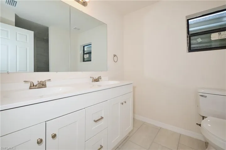 Bathroom featuring vanity, tile patterned floors, and toilet