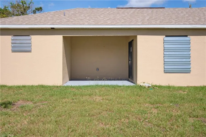 Rear view of house featuring a yard