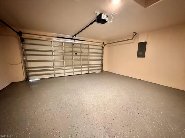 Garage featuring a garage door opener and electric panel
