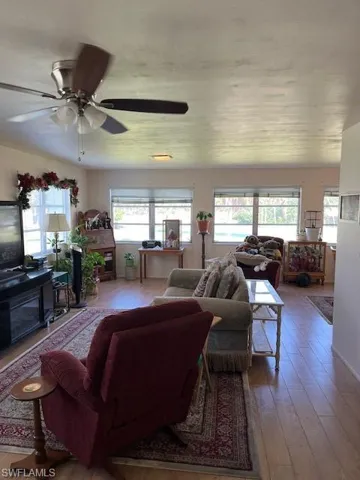 Living room with ceiling fan and hardwood / wood-style flooring