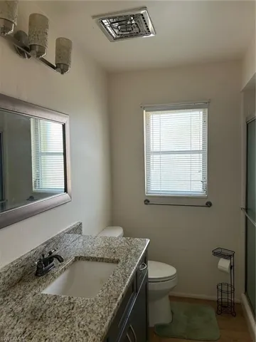 Bathroom featuring hardwood / wood-style floors, toilet, and vanity