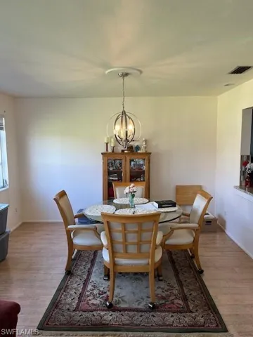 Dining area with a notable chandelier and hardwood / wood-style floors