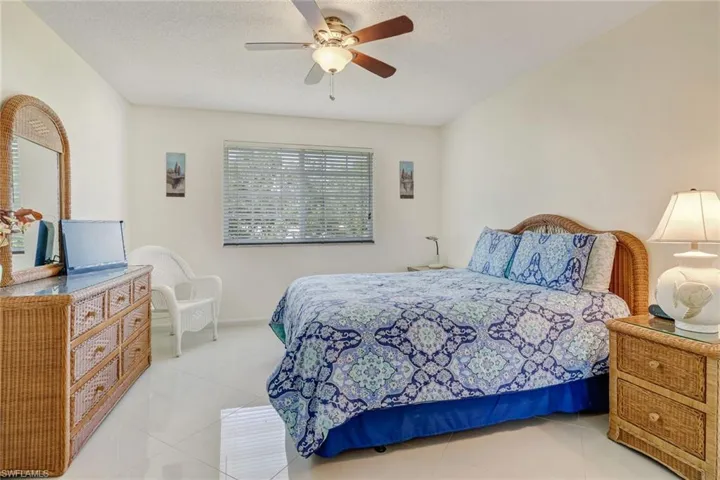 Tiled bedroom with ceiling fan and a textured ceiling