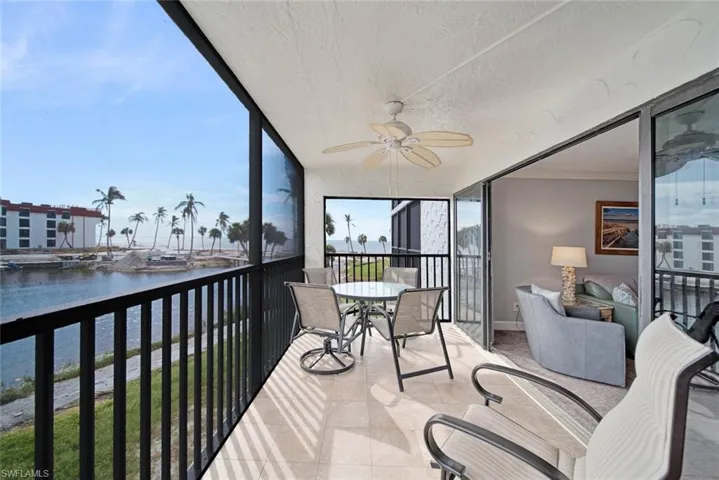 Sunroom / solarium with a water view and ceiling fan