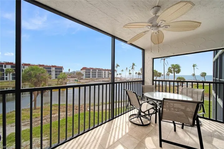 Sunroom / solarium with a water view and ceiling fan