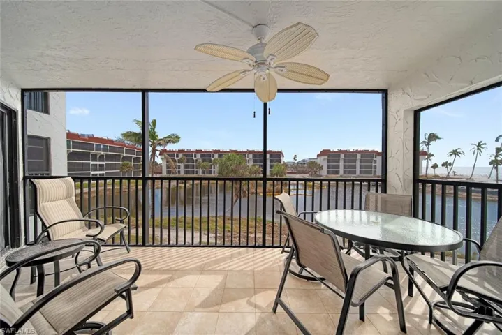 Sunroom featuring plenty of natural light, a water view, and ceiling fan