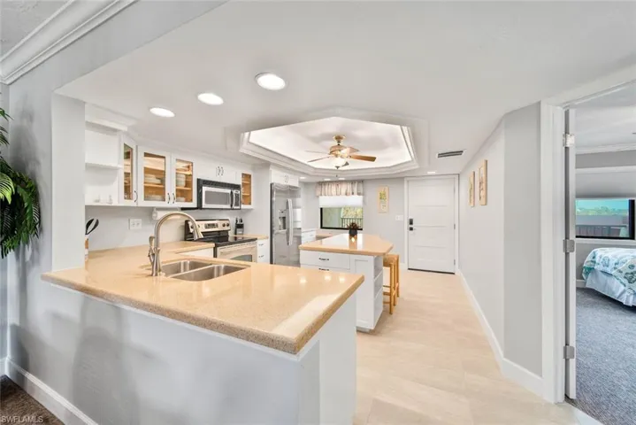 Kitchen featuring white cabinetry, appliances with stainless steel finishes, sink, and kitchen peninsula
