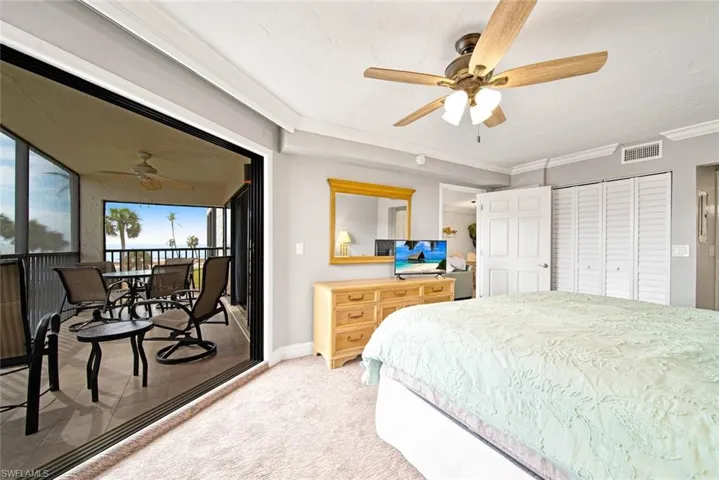 Carpeted bedroom featuring ornamental molding, a closet, and ceiling fan