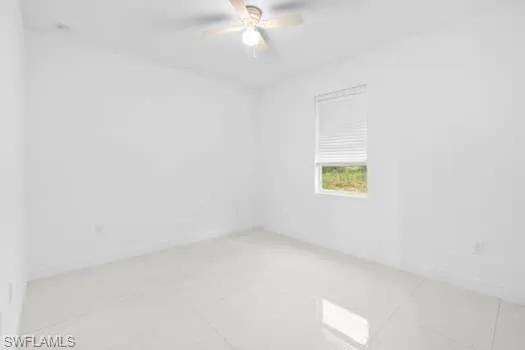 Empty room with ceiling fan and tile patterned flooring