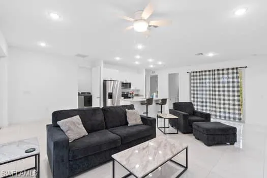 Living room with light tile patterned floors and ceiling fan