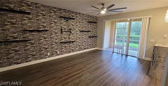 Spare room with dark wood finished floors and ceiling fan