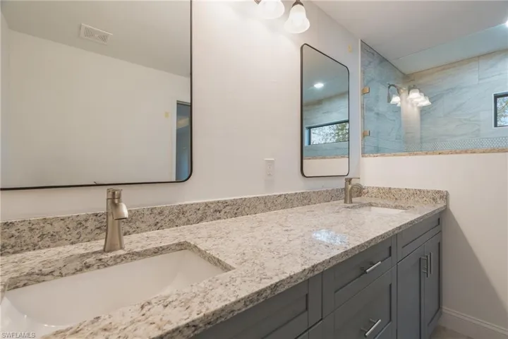 Full bathroom featuring double vanity and a walk in shower