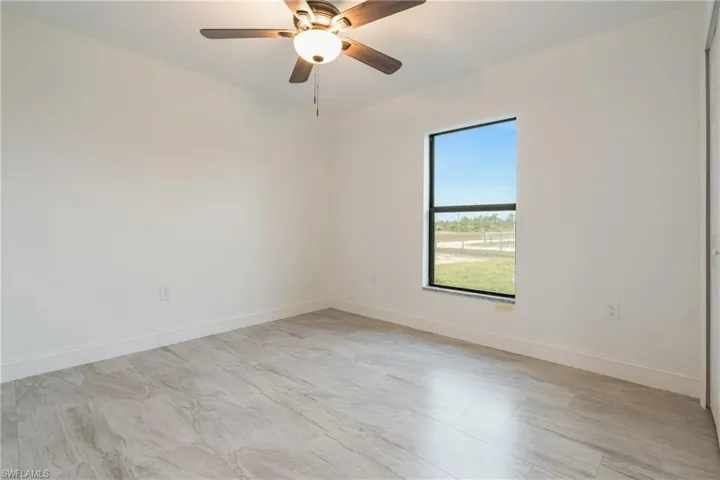 Empty room featuring baseboards and ceiling fan