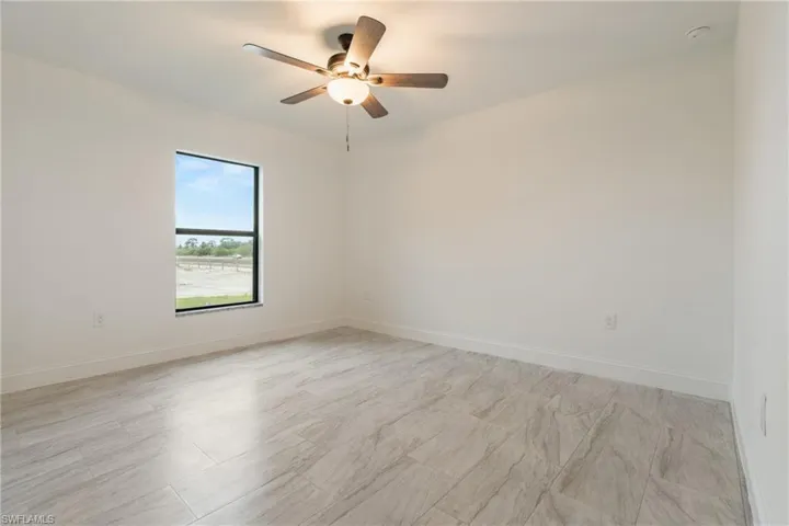 Empty room with baseboards and ceiling fan