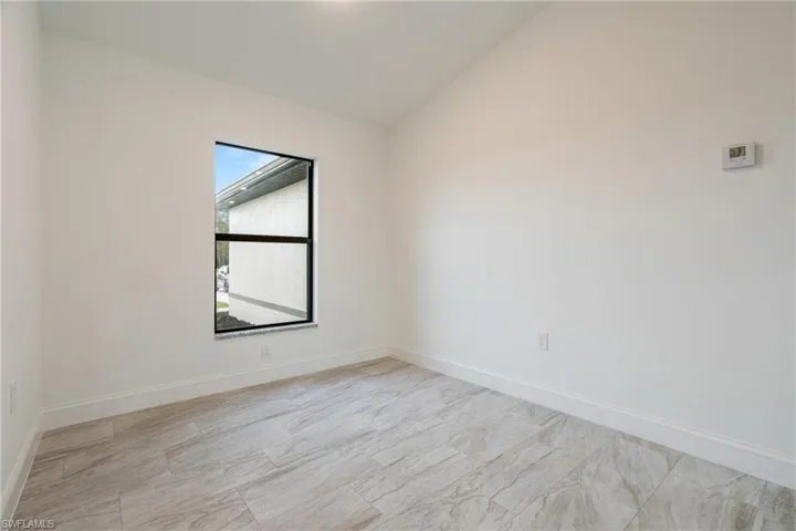 Spare room with lofted ceiling and baseboards