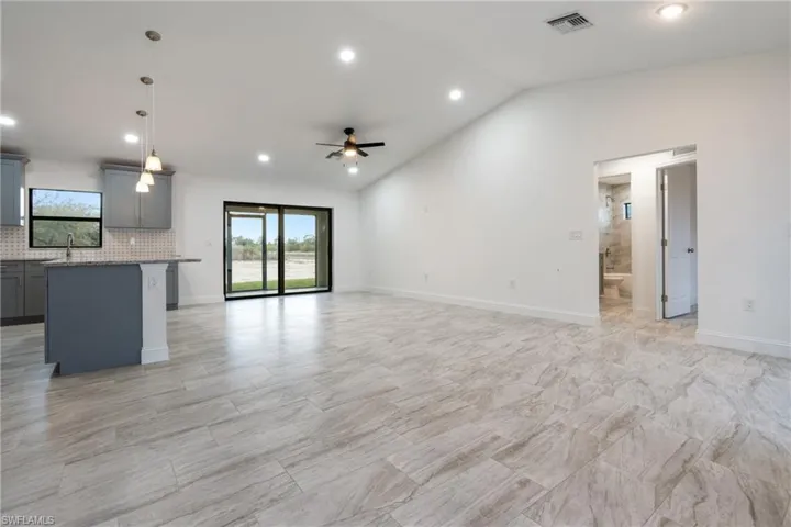 Unfurnished living room featuring recessed lighting, vaulted ceiling, and ceiling fan