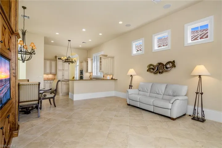 Family room with modern open visibility to kitchen. Tile flooring.