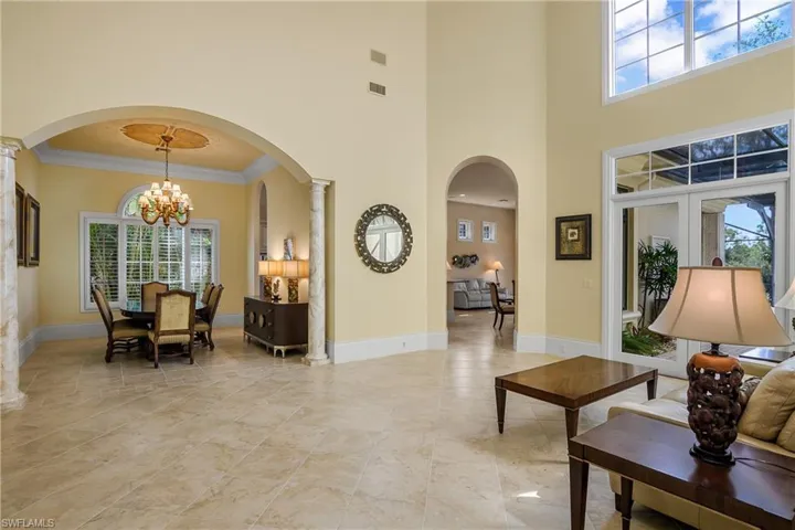 Living room with entry to dining room and family room. French doors open to lanai.