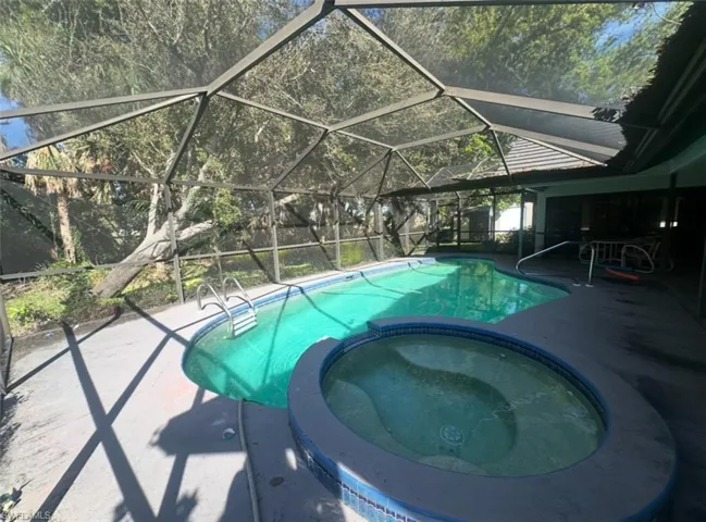 View of swimming pool featuring a patio, a lanai, and a pool with connected hot tub