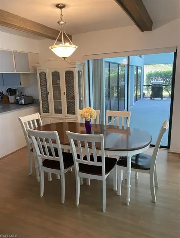 Dining space featuring wood finished floors and beam ceiling