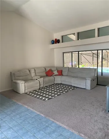 Unfurnished living room with lofted ceiling and carpet flooring
