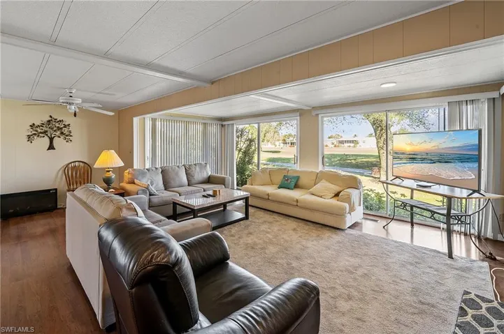 Living area featuring ceiling fan, wood finished floors, and wood walls