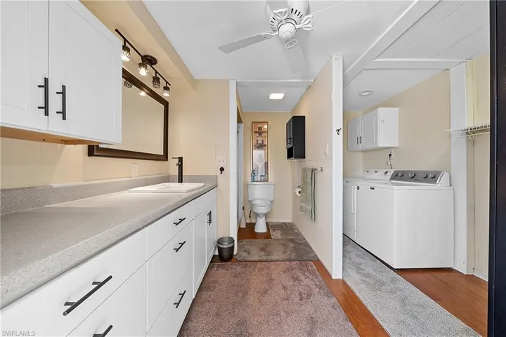 Full bath with vanity, independent washer and dryer, ceiling fan, and a walk in closet