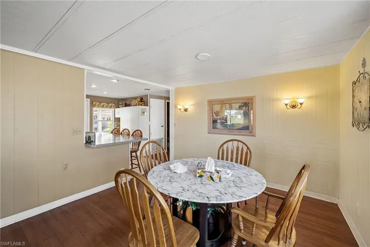 Dining area with dark wood finished floors and wooden walls