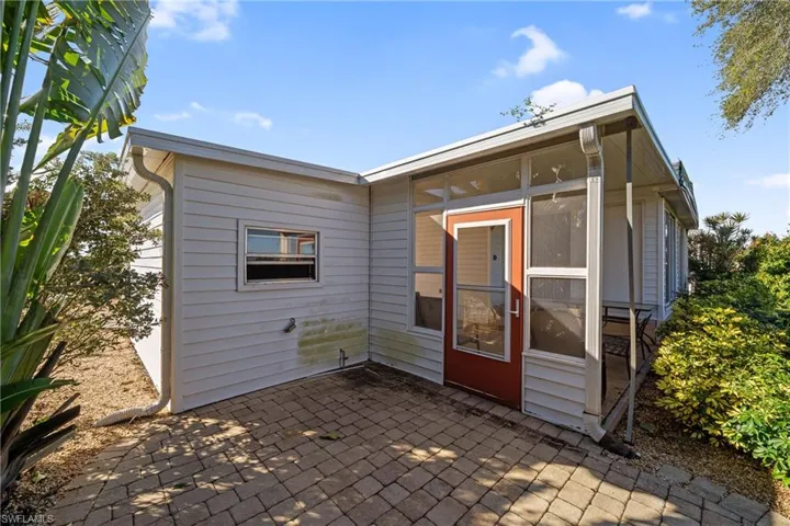 Back of house with a sunroom and a patio area