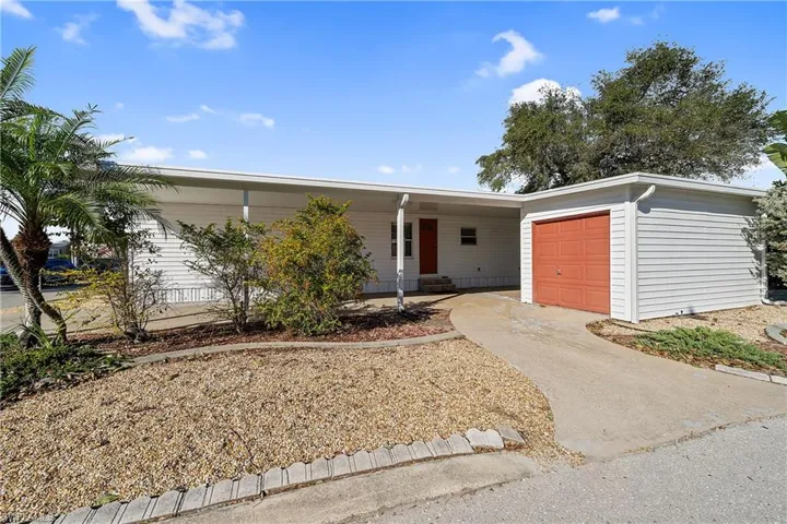 Single story home featuring a porch, driveway, and a garage