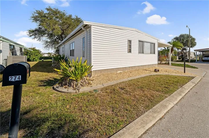 View of side of property with a lawn and a carport
