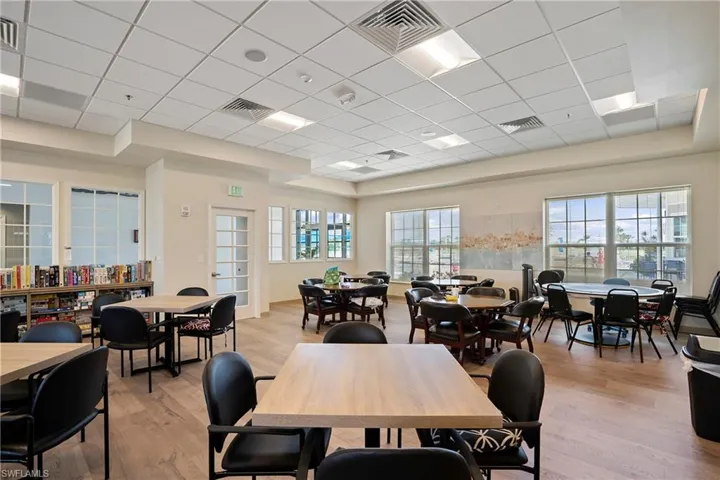 Dining area with light wood-style floors, plenty of natural light, and a drop ceiling